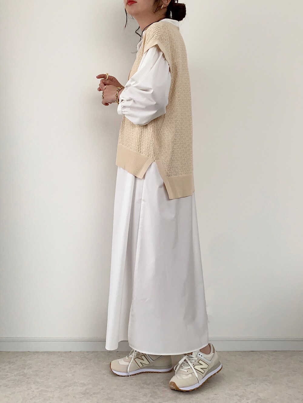 ベージュ系のベスト、ホワイト系のシャツワンピース、イエロー系のショルダーバッグを着用したレディースの夏コーディネートの4枚目の写真