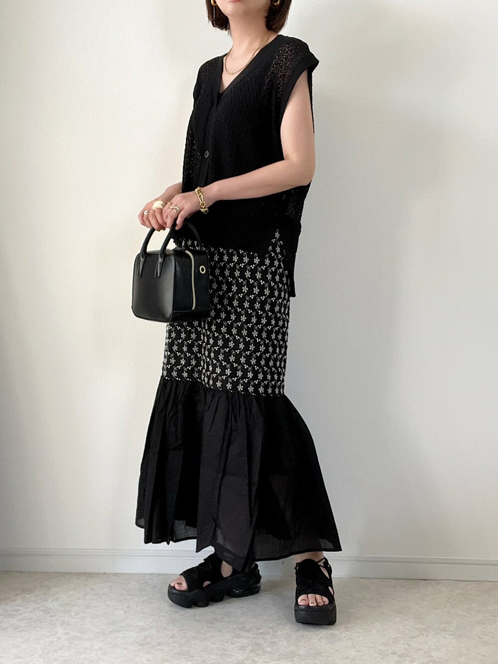 ブラック系のベスト、その他のワンピース、ブラック系のバッグを着用したレディースの夏コーディネートの2枚目の写真