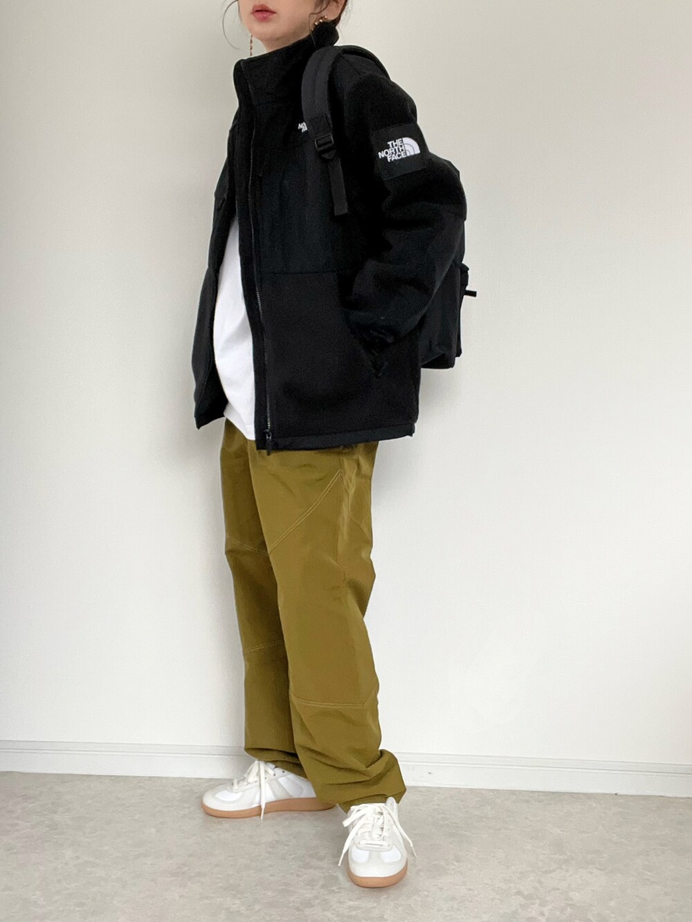 グリーン系のスラックス、ホワイト系のTシャツ/カットソーを着用したレディースの冬コーディネートの4枚目の写真