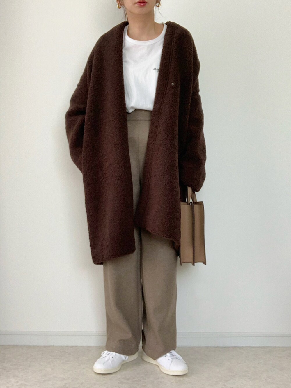 ブラウン系のノーカラーコート、ブラック系のスウェット、グレー系のその他パンツを着用したレディースの秋コーディネートの3枚目の写真