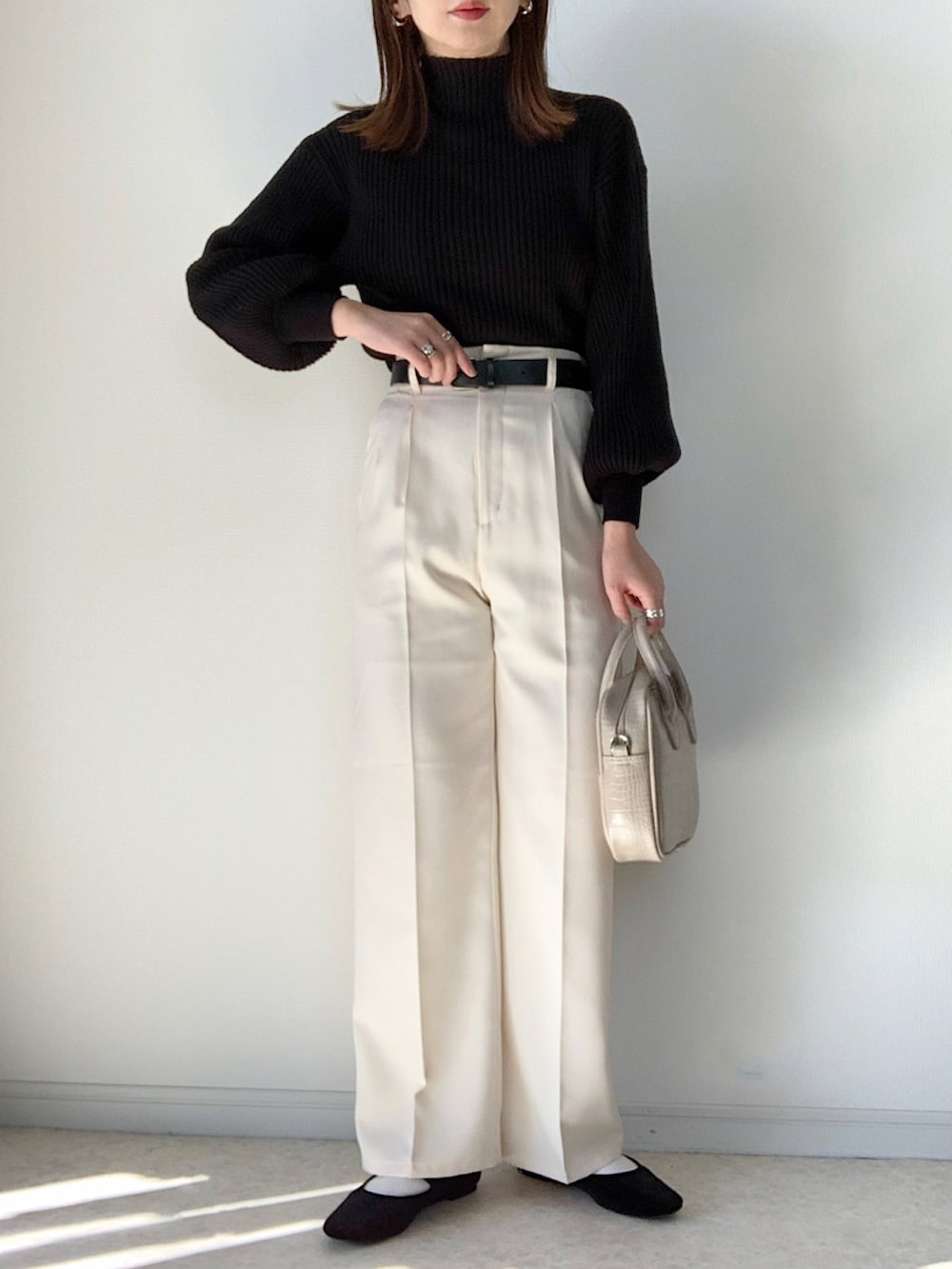 ホワイト系のパンツ、ブラック系のショルダーバッグ、ホワイト系のスニーカーを着用したレディースの冬コーディネートの3枚目の写真