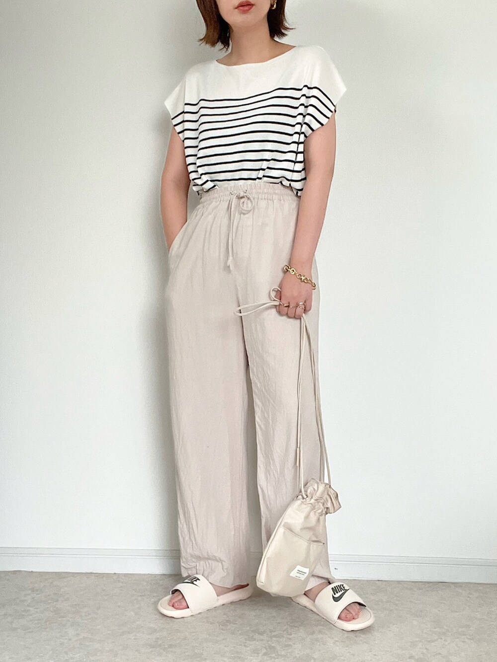 グリーン系のベスト、ホワイト系のニット/セーター、ホワイト系のその他パンツを着用したレディースの夏コーディネートの2枚目の写真