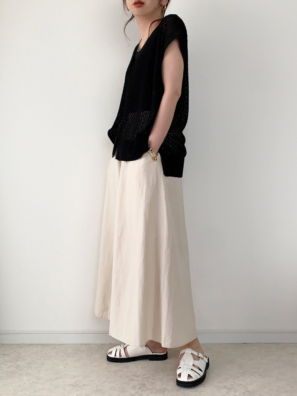 ブラック系のベスト、その他のワンピース、ブラック系のバッグを着用したレディースの夏コーディネートの4枚目の写真