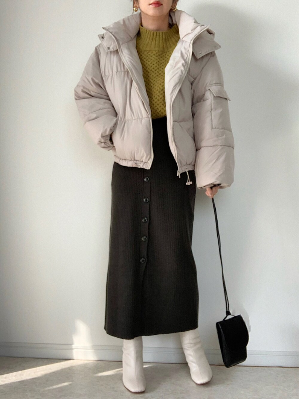 ホワイト系のダウンジャケット/コート、グレー系のワンピース、ベージュ系のショルダーバッグを着用したレディースの秋コーディネートの3枚目の写真