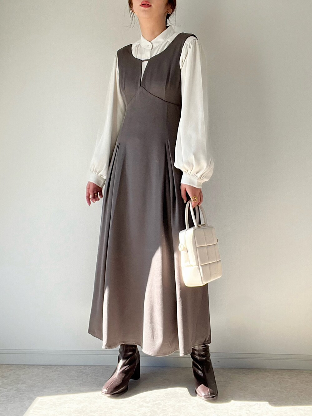 グレー系のワンピース/ドレス、ブラウン系のブーツ、ゴールド系のリングを着用したレディースの冬コーディネートの2枚目の写真