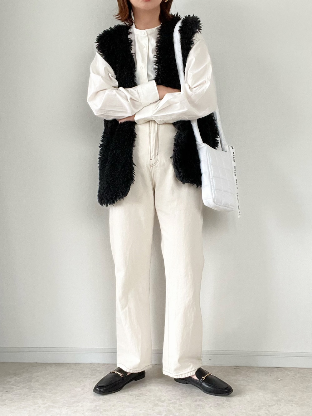 ブラック系のベスト、ホワイト系のスウェット、ブラウン系のその他パンツを着用したレディースの秋コーディネートの2枚目の写真