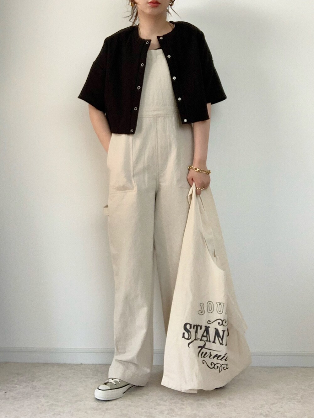 グリーン系のTシャツ/カットソー、ベージュ系のサロペット/オーバーオール、イエロー系のトートバッグを着用したレディースの春コーディネートの2枚目の写真