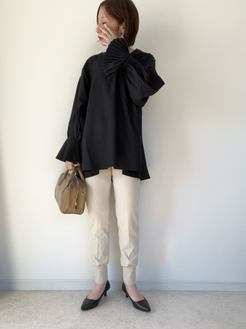 ブラック系のシャツ/ブラウス、ブラウン系のショルダーバッグ、ブラック系のパンプスを着用したレディースの冬コーディネートの3枚目の写真