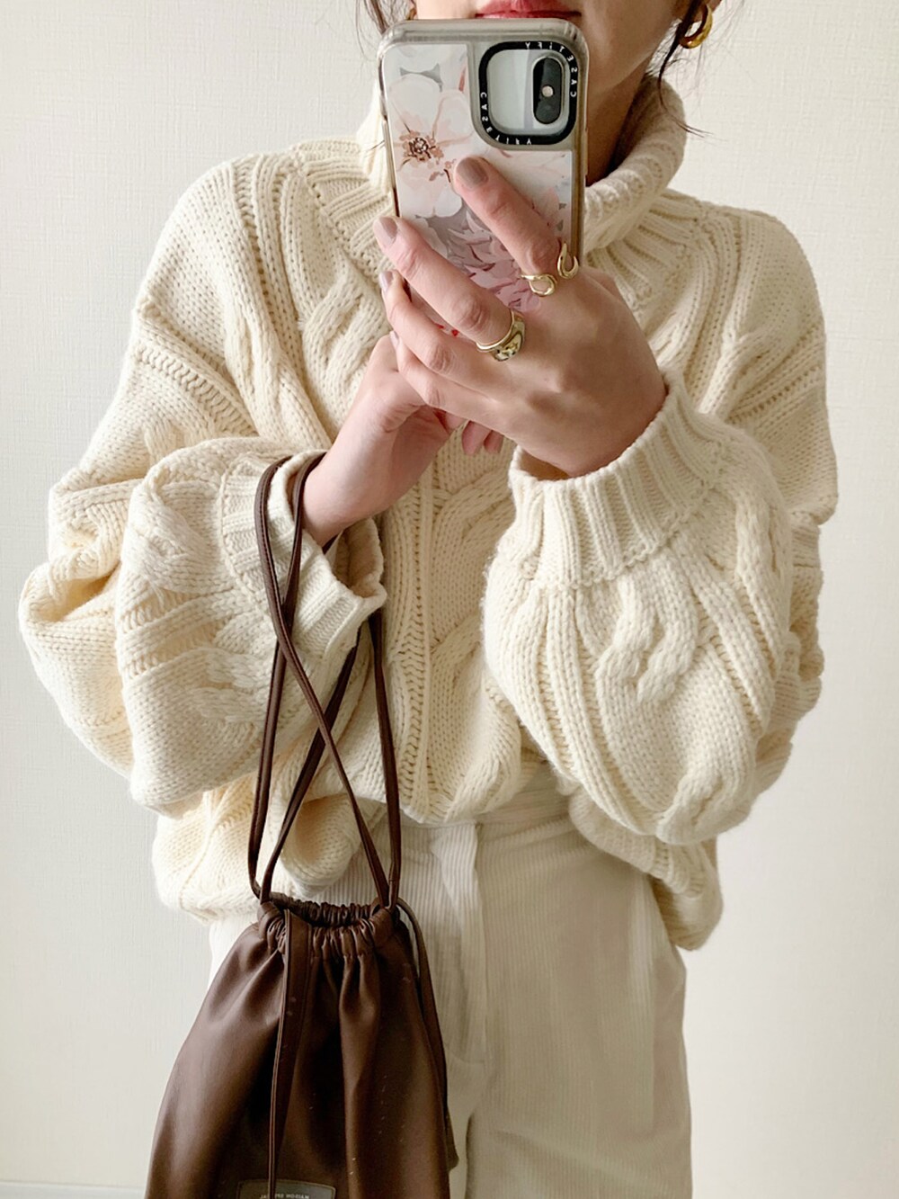 ホワイト系のニット/セーター、ホワイト系のスラックス、ベージュ系のスニーカーを着用したレディースの冬コーディネートの2枚目の写真