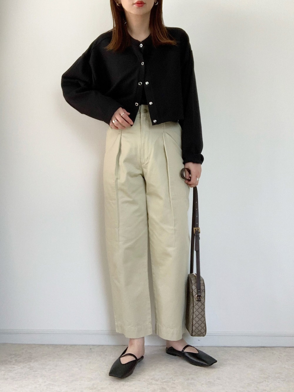 ブラック系のカーディガン/ボレロ、ブラック系のキャミソール、ブラウン系のスラックスを着用したレディースの春コーディネートの3枚目の写真