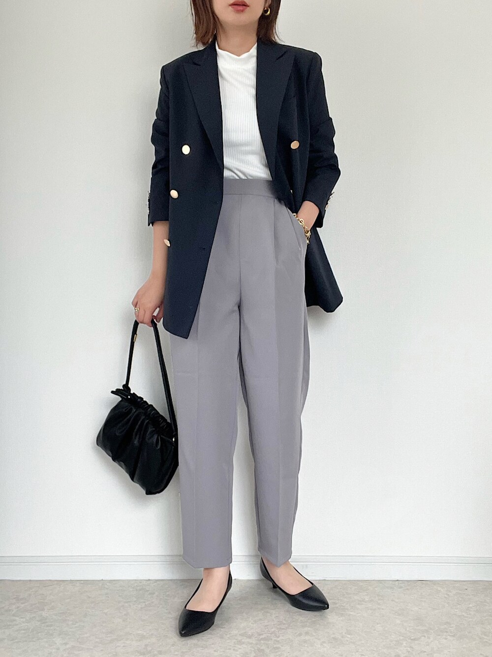 ブラック系のパンプス、ブラック系のバッグ、ブラック系のベストを着用したレディースの夏コーディネートの2枚目の写真