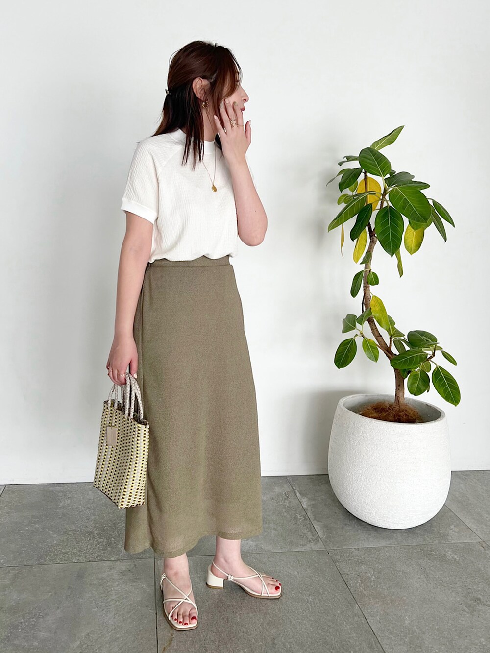 ホワイト系のニット/セーター、ブラック系のTシャツ/カットソー、ブルー系のデニムパンツを着用したレディースの春コーディネートの2枚目の写真