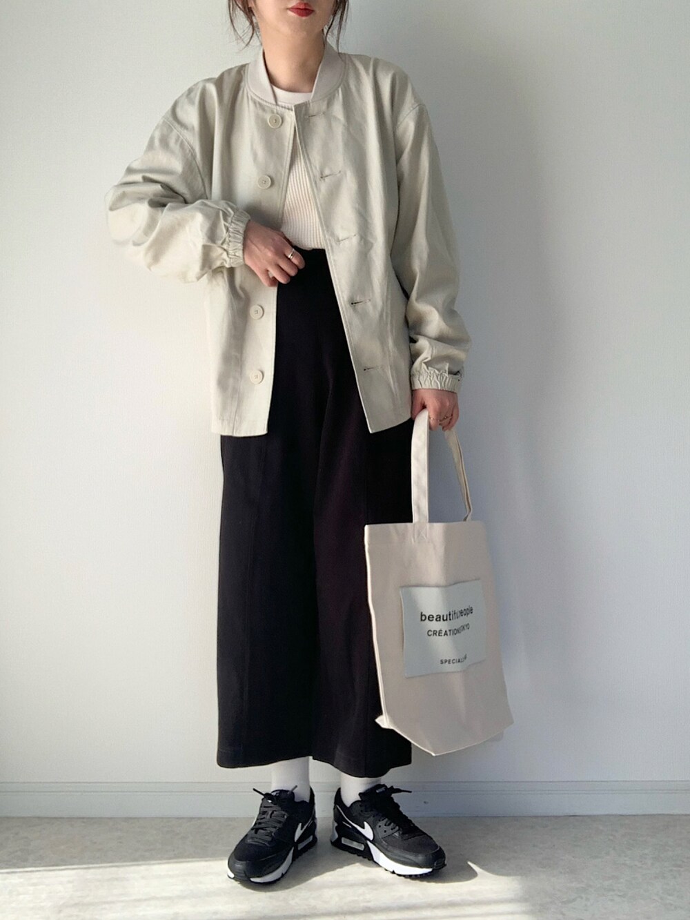 ホワイト系のTシャツ/カットソー、ブルー系のデニムパンツ、ブラック系のショルダーバッグを着用したレディースの春コーディネートの5枚目の写真