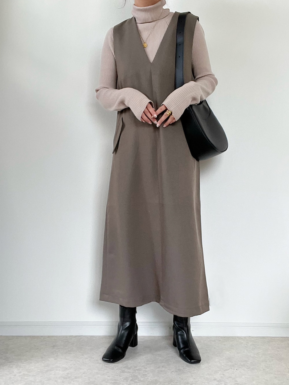 ベージュ系のニット/セーター、ベージュ系のステンカラーコート、シルバー系のショルダーバッグを着用したレディースの秋コーディネートの2枚目の写真