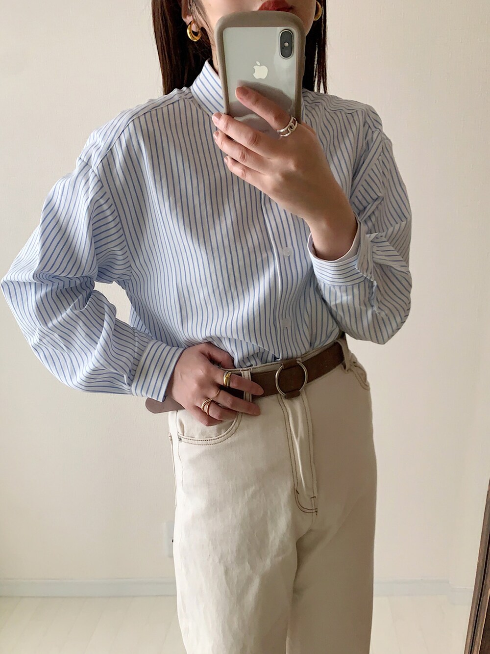 ブルー系のシャツ/ブラウス、オレンジ系のカーディガン/ボレロ、ブルー系のデニムパンツを着用したレディースの春コーディネートの2枚目の写真