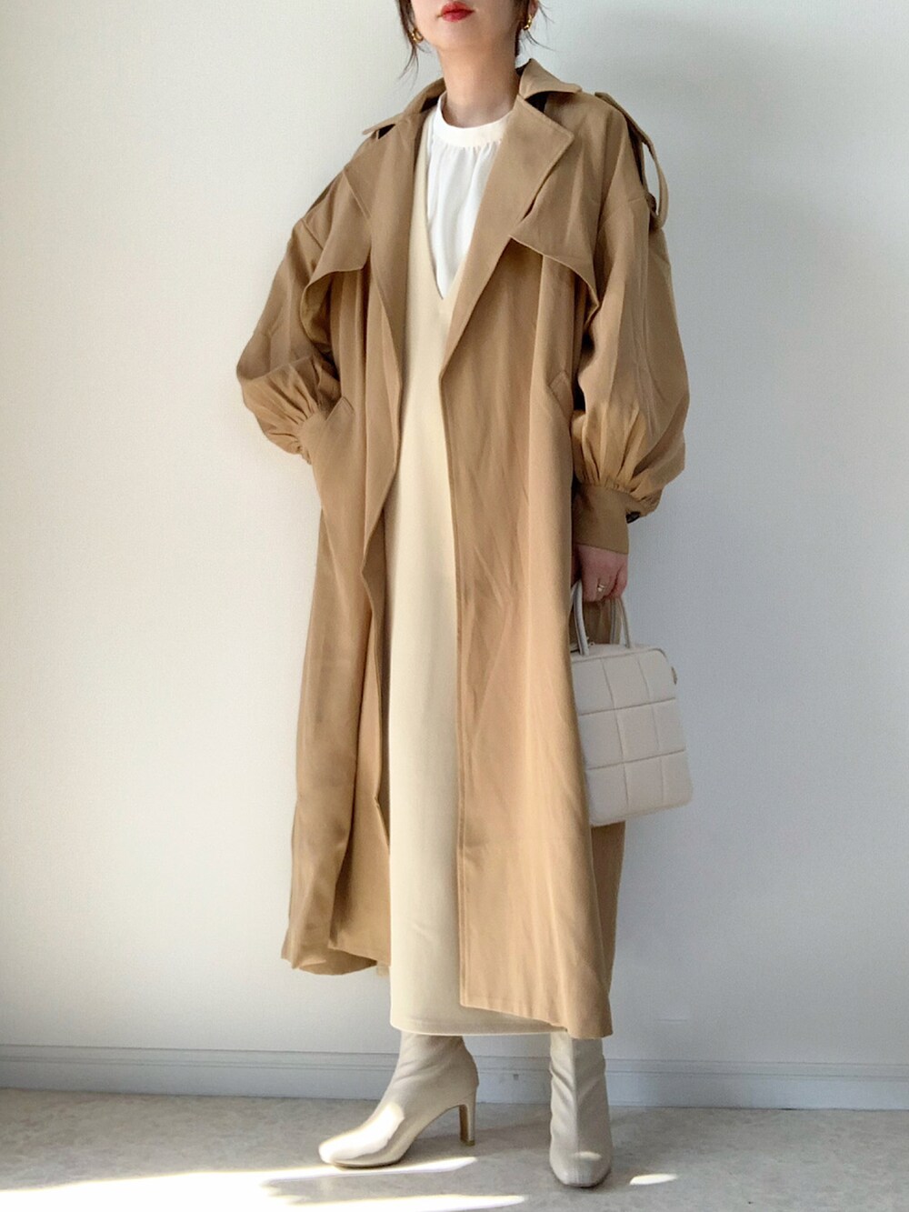 ベージュ系のトレンチコート、ホワイト系のTシャツ/カットソー、ベージュ系のその他パンツを着用したレディースの冬コーディネートの2枚目の写真