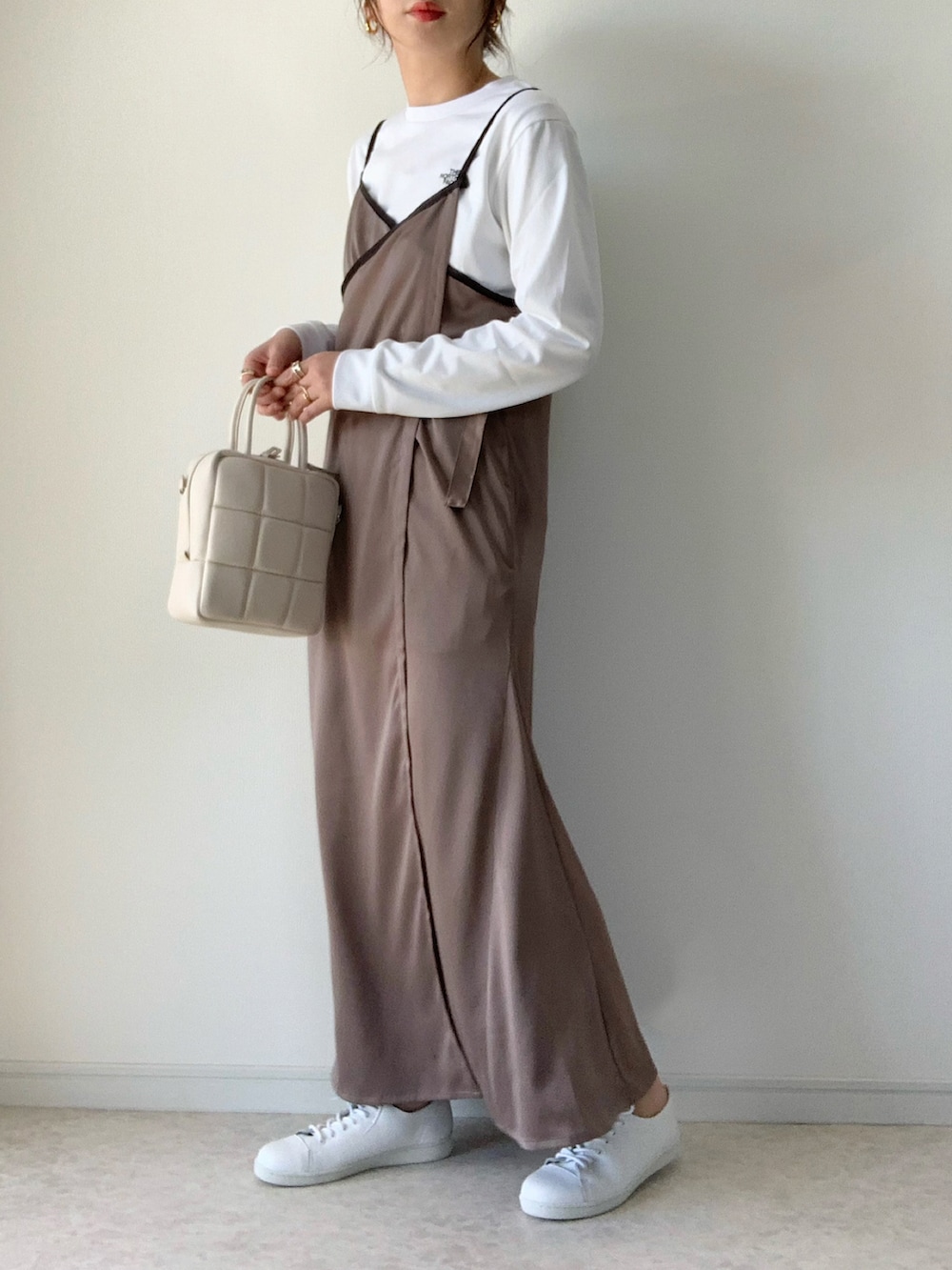 ブラック系のナイロンジャケット、グレー系のワンピース、ホワイト系のスニーカーを着用したレディースの春コーディネートの3枚目の写真