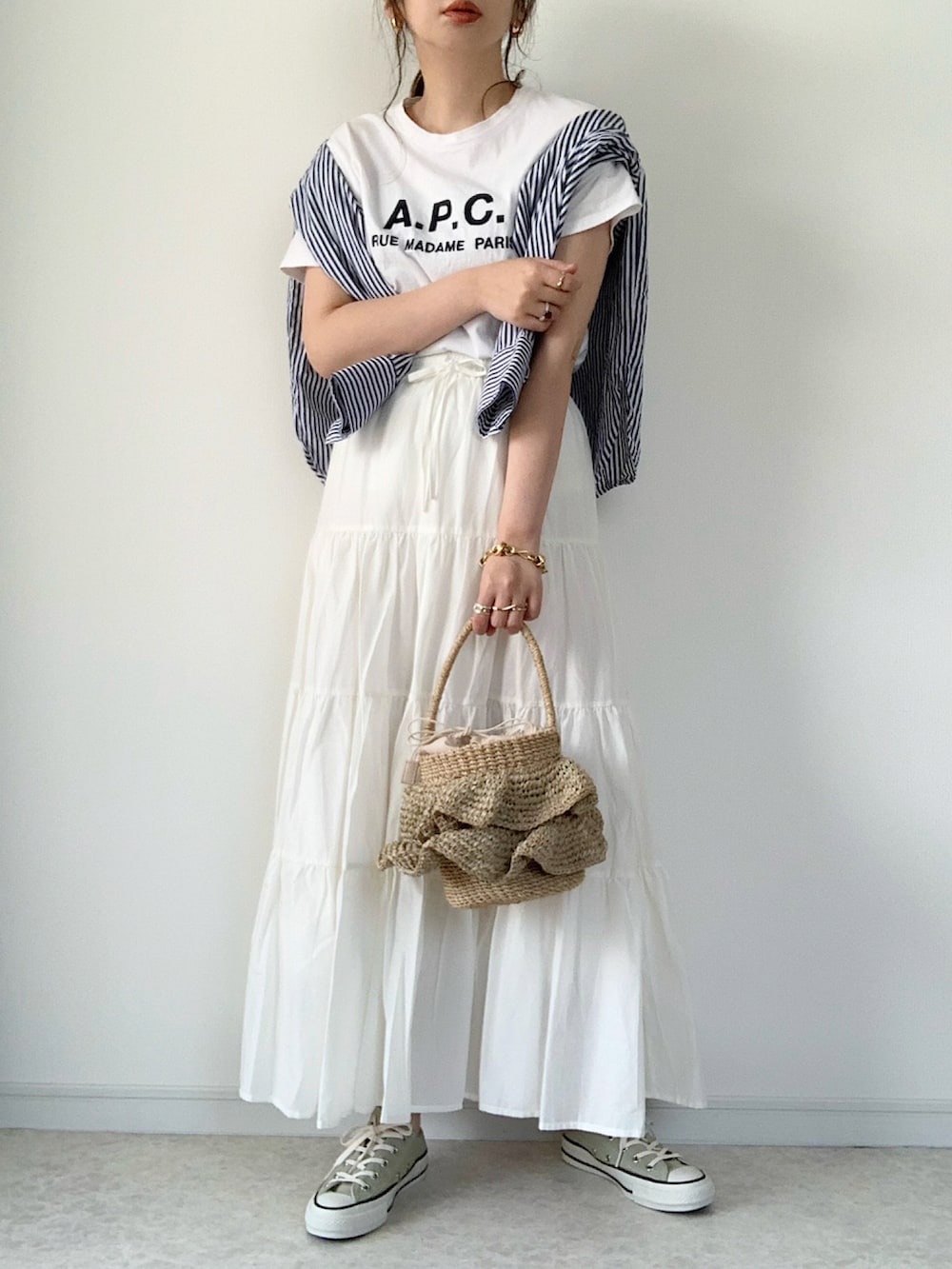 ブラック系のTシャツ/カットソー、ホワイト系のスカート、ブラック系のサンダルを着用したレディースの春コーディネートの3枚目の写真