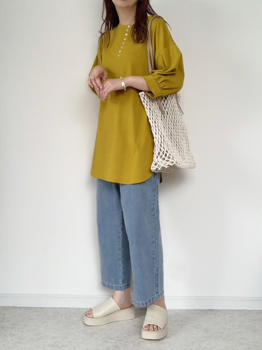 イエロー系のTシャツ/カットソー、ブラウン系のスカート、ホワイト系のサンダルを着用したレディースの夏コーディネートの2枚目の写真