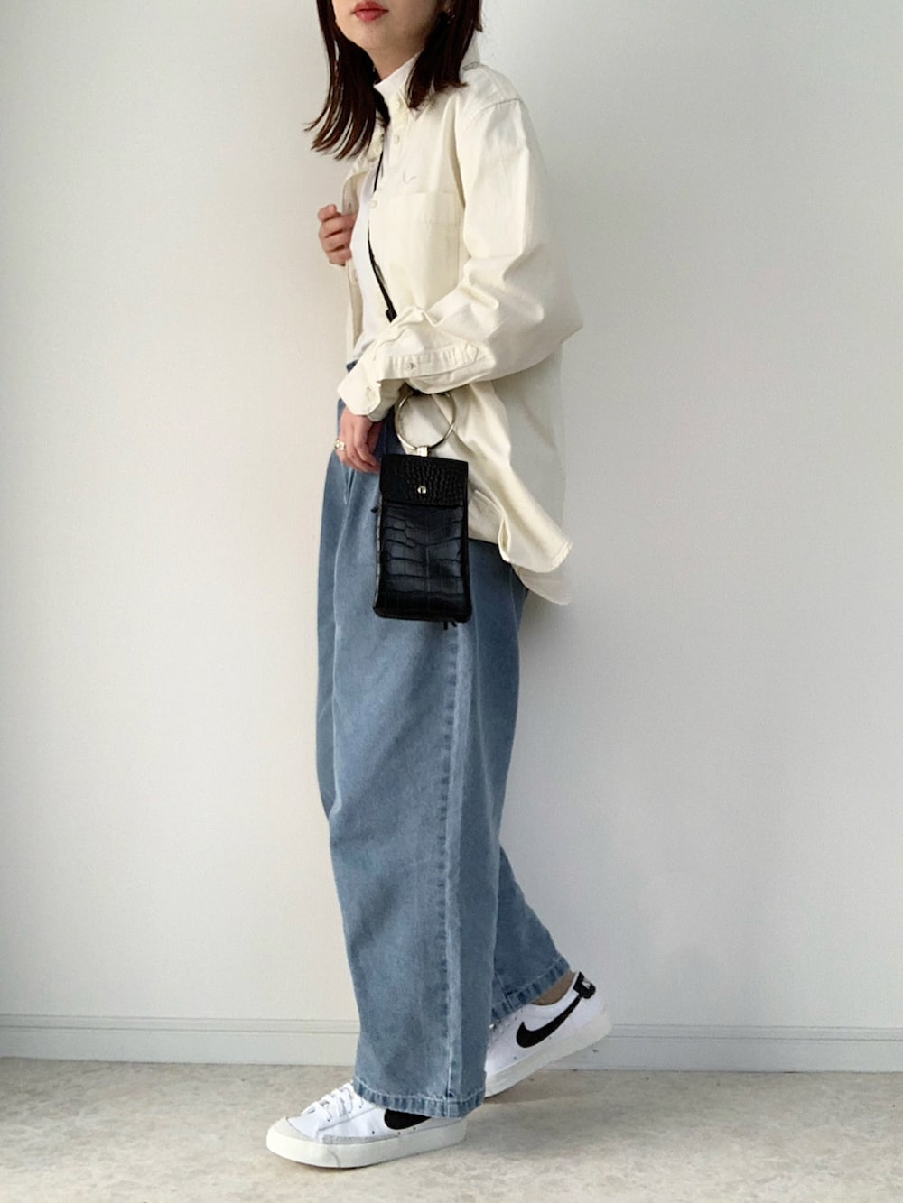 ホワイト系のTシャツ/カットソー、ブルー系のデニムパンツ、ベージュ系のスニーカーを着用したレディースの冬コーディネートの3枚目の写真