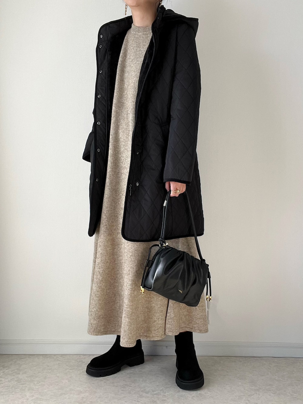 ブラック系のその他アウター、ホワイト系のTシャツ/カットソー、ホワイト系のハンドバッグを着用したレディースの冬コーディネートの5枚目の写真