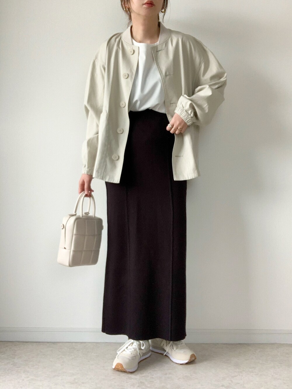 グリーン系のカーディガン/ボレロ、ブラック系のトートバッグ、ブラック系のスカートを着用したレディースの春コーディネートの2枚目の写真