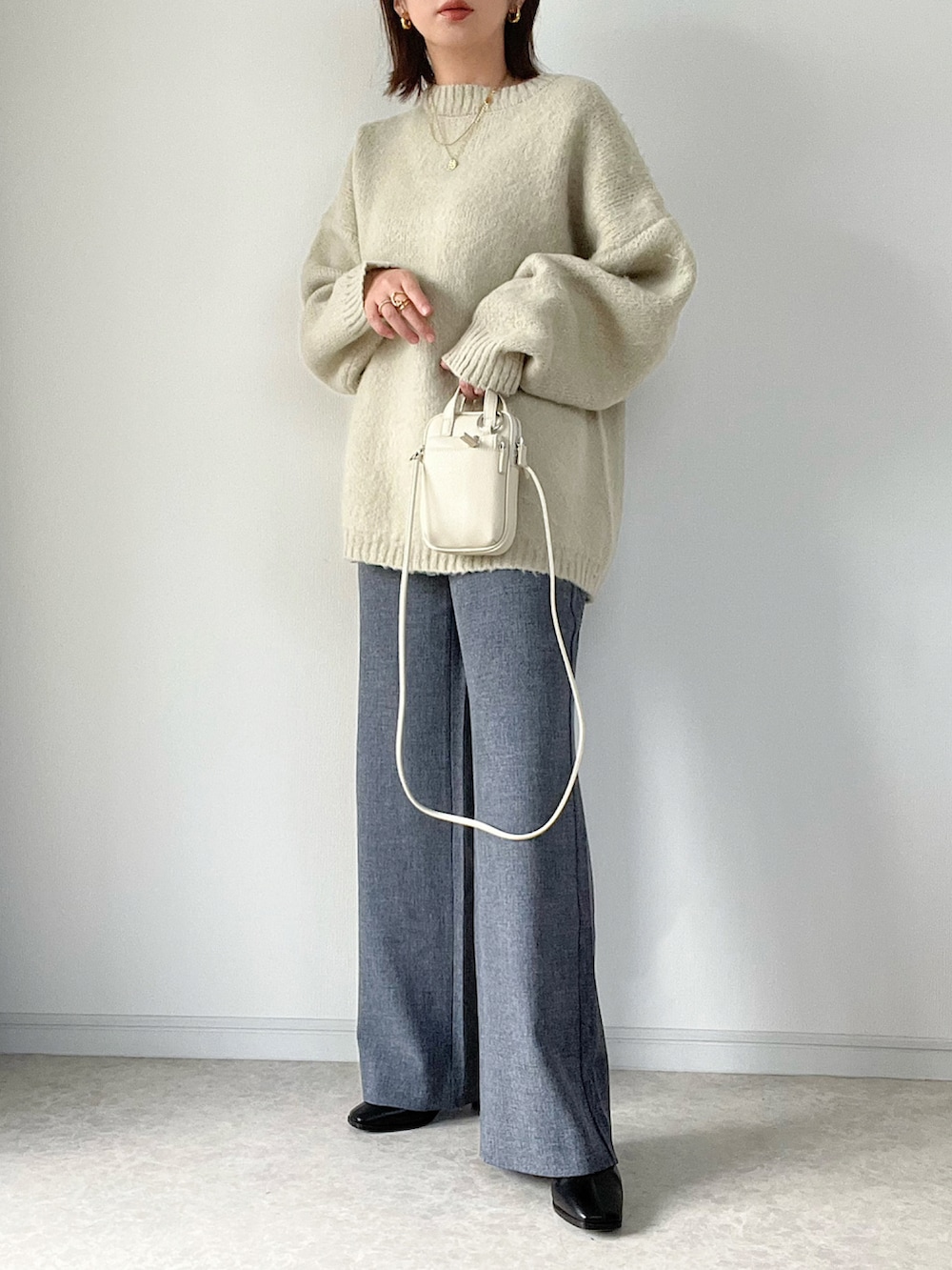 ベージュ系のニット/セーター、ブラック系のその他パンツ、ブラック系のバッグを着用したレディースの秋コーディネートの2枚目の写真