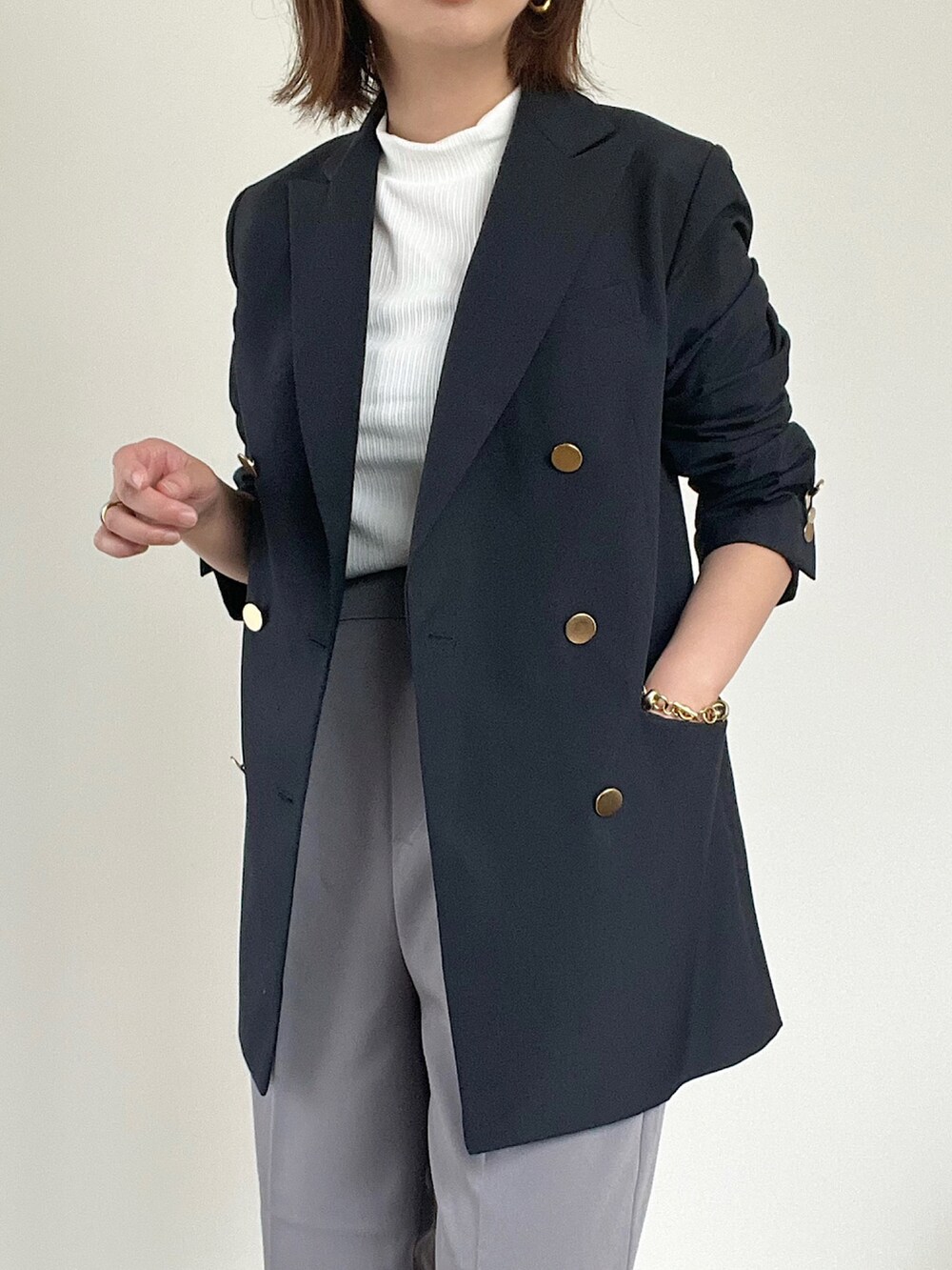 ブルー系のテーラードジャケット、ホワイト系のTシャツ/カットソー、グリーン系のスラックスを着用したレディースの夏コーディネートの4枚目の写真