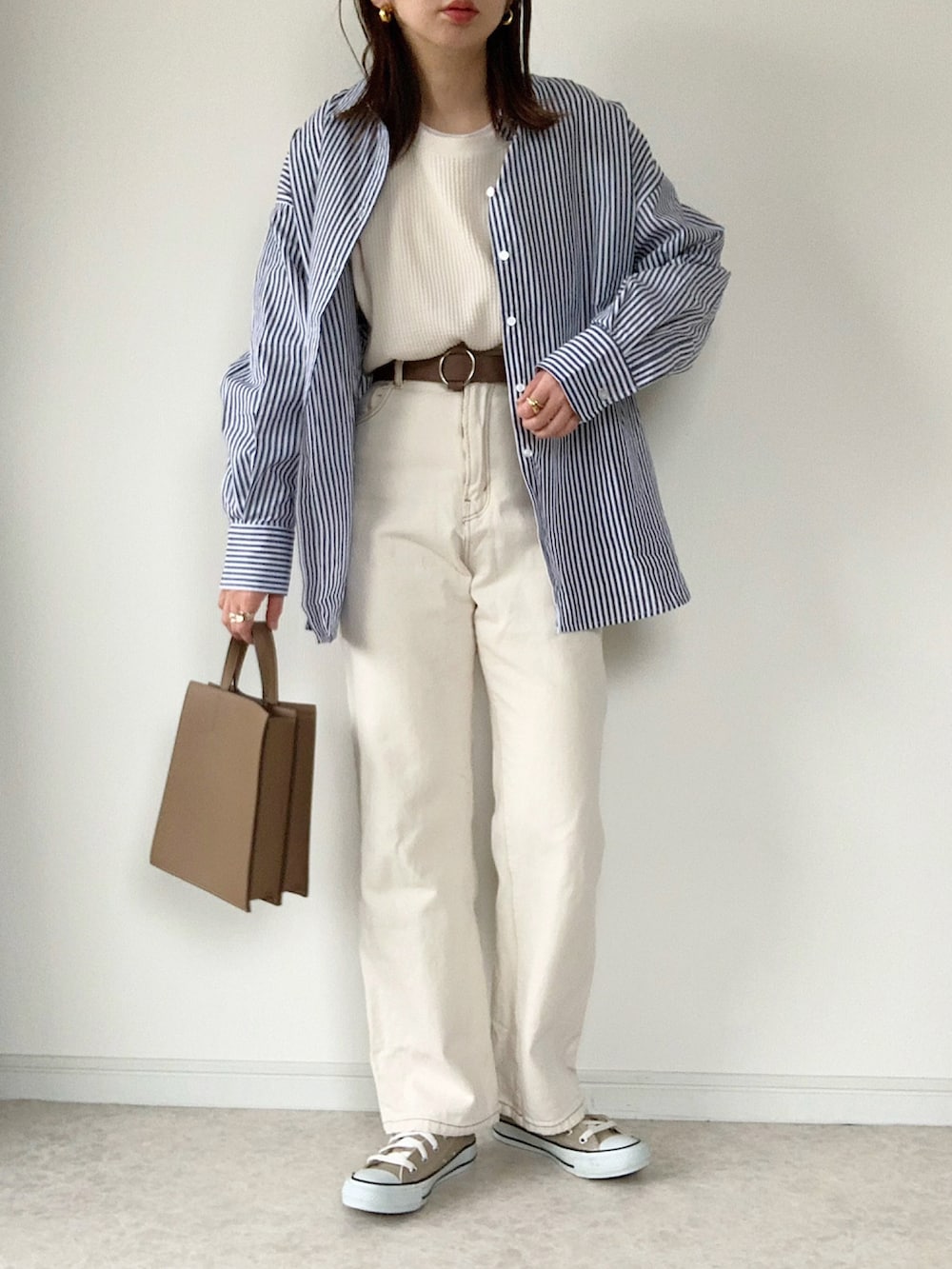 ホワイト系のTシャツ/カットソー、グレー系のニット/セーター、ブラック系のショルダーバッグを着用したレディースの冬コーディネートの3枚目の写真