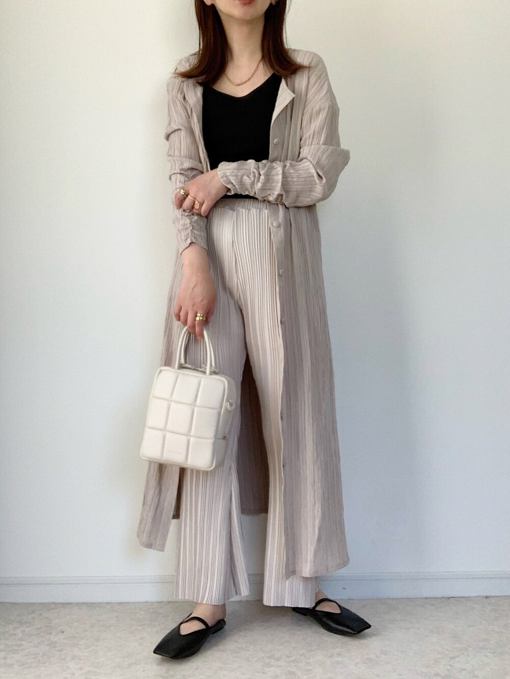 ベージュ系のシャツワンピース、ホワイト系のその他パンツ、ホワイト系のショルダーバッグを着用したレディースの春コーディネートの2枚目の写真