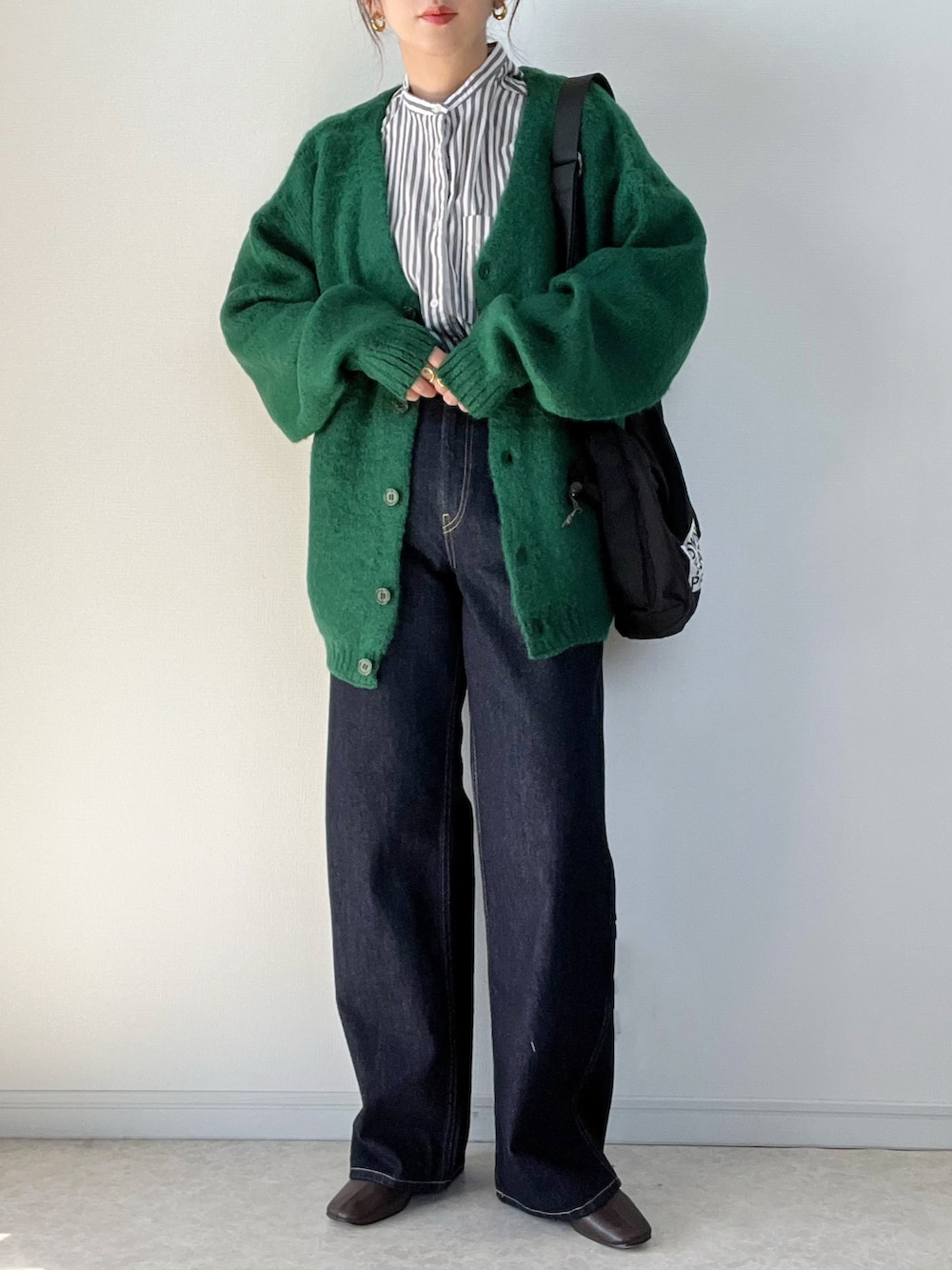 グリーン系のカーディガン/ボレロ、ホワイト系のTシャツ/カットソー、グレー系のスニーカーを着用したレディースの秋コーディネートの3枚目の写真