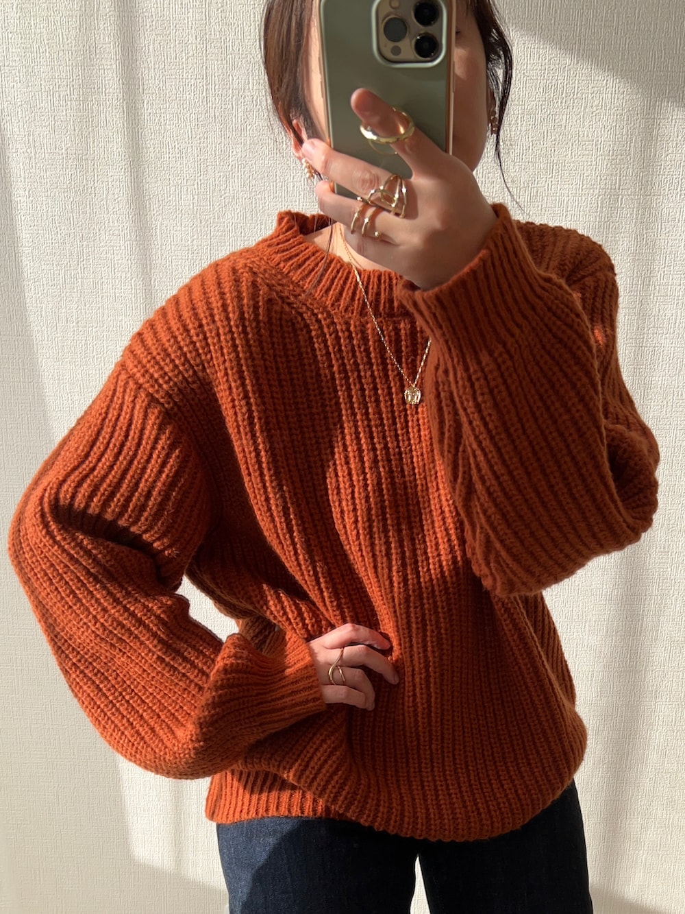 イエロー系のニット/セーター、ブルー系のデニムパンツ、ホワイト系のハンドバッグを着用したレディースの秋コーディネートの2枚目の写真