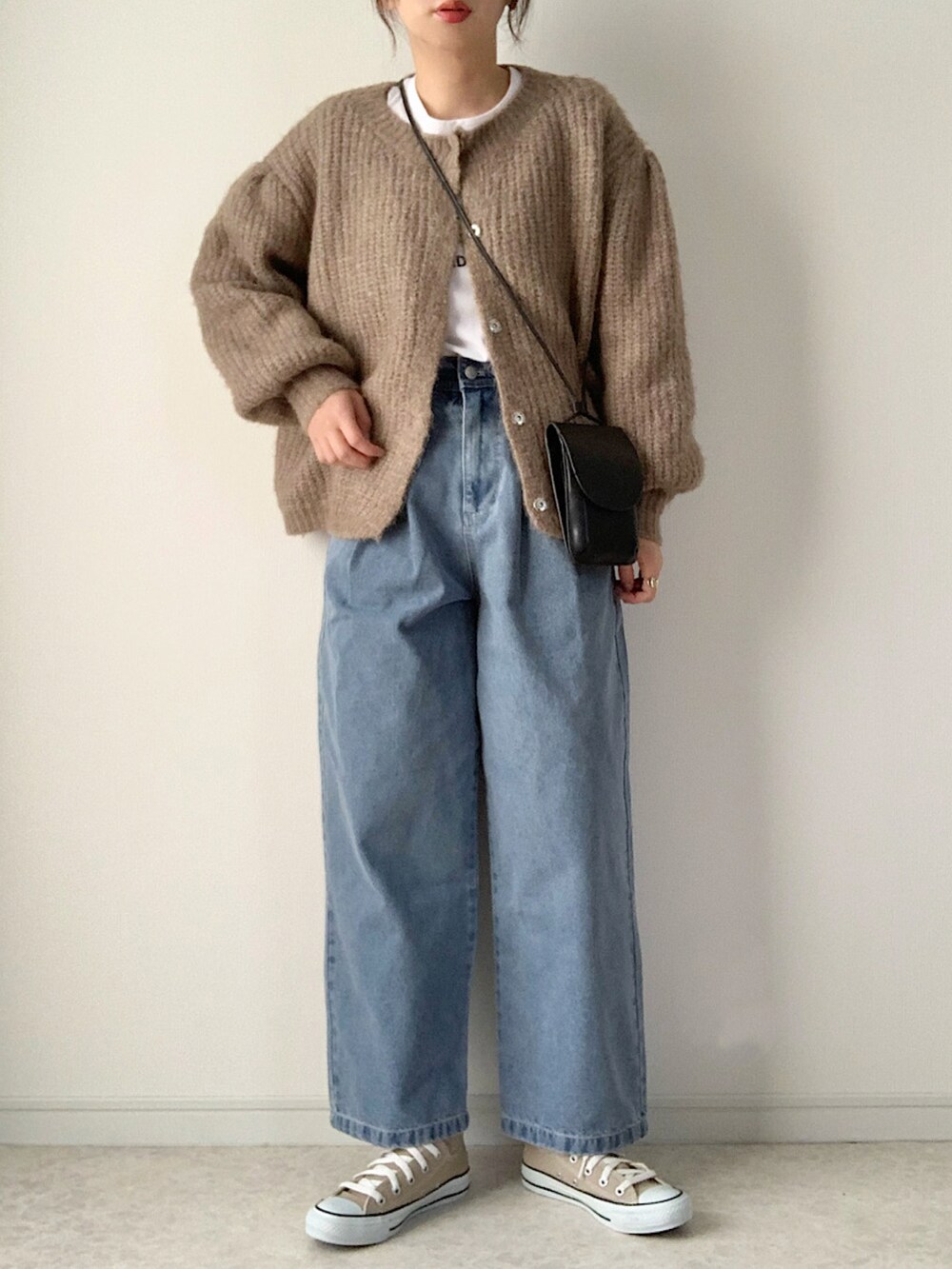 ホワイト系のスウェット、ブルー系のデニムパンツ、ホワイト系のスニーカーを着用したレディースの冬コーディネートの2枚目の写真