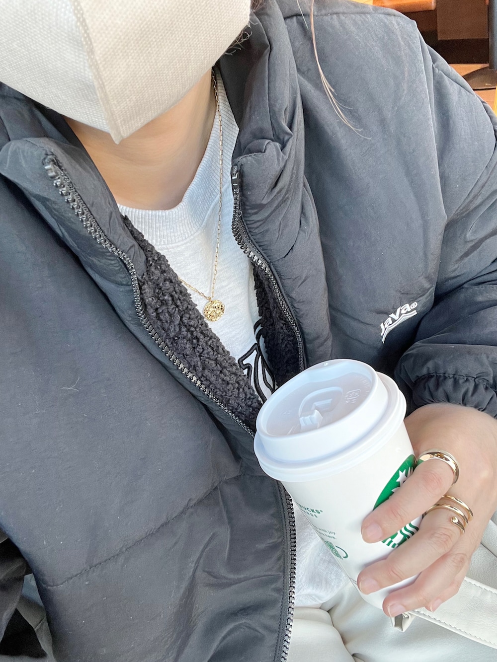 ブラック系のブルゾン、ホワイト系のスウェット、ホワイト系のパンツを着用したレディースの冬コーディネートの4枚目の写真