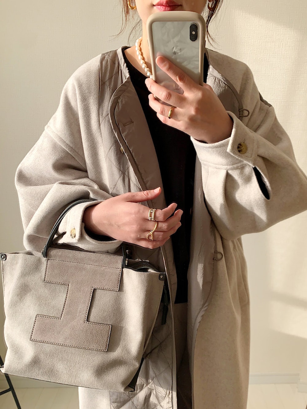 ベージュ系のノーカラーコート、ベージュ系のその他パンツ、ブラック系のスウェットを着用したレディースの冬コーディネートの2枚目の写真