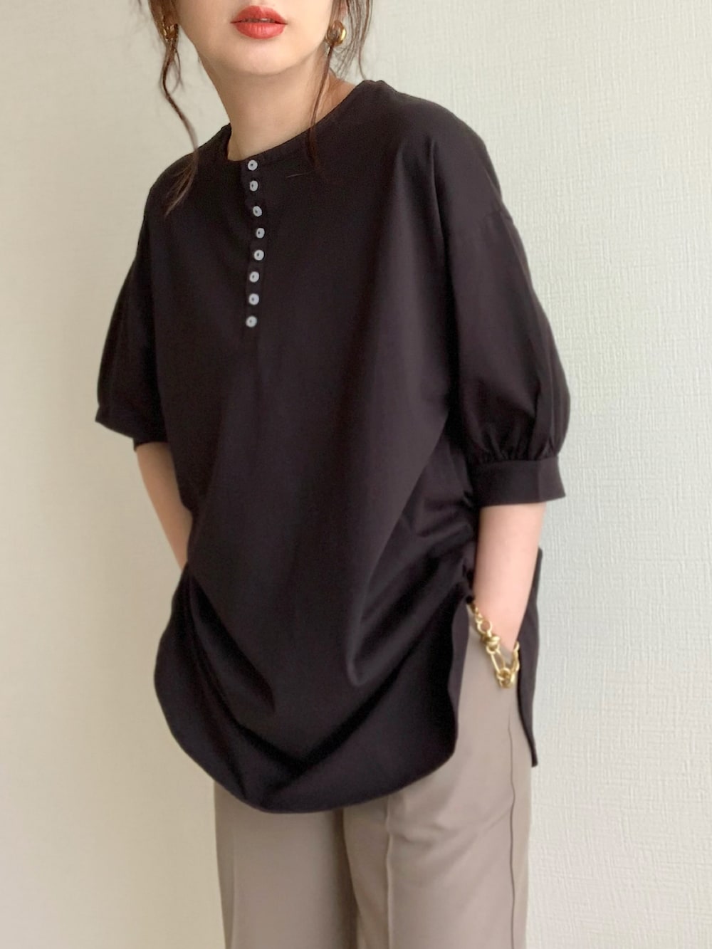 ブラック系のTシャツ/カットソー、グレー系のスラックス、ホワイト系のパンプスを着用したレディースの夏コーディネートの3枚目の写真