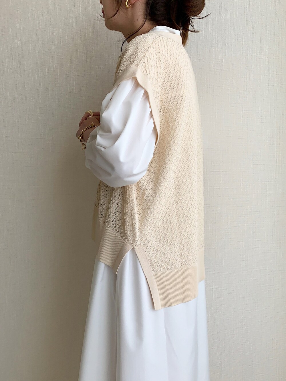 ベージュ系のベスト、ホワイト系のシャツワンピース、イエロー系のショルダーバッグを着用したレディースの夏コーディネートの3枚目の写真