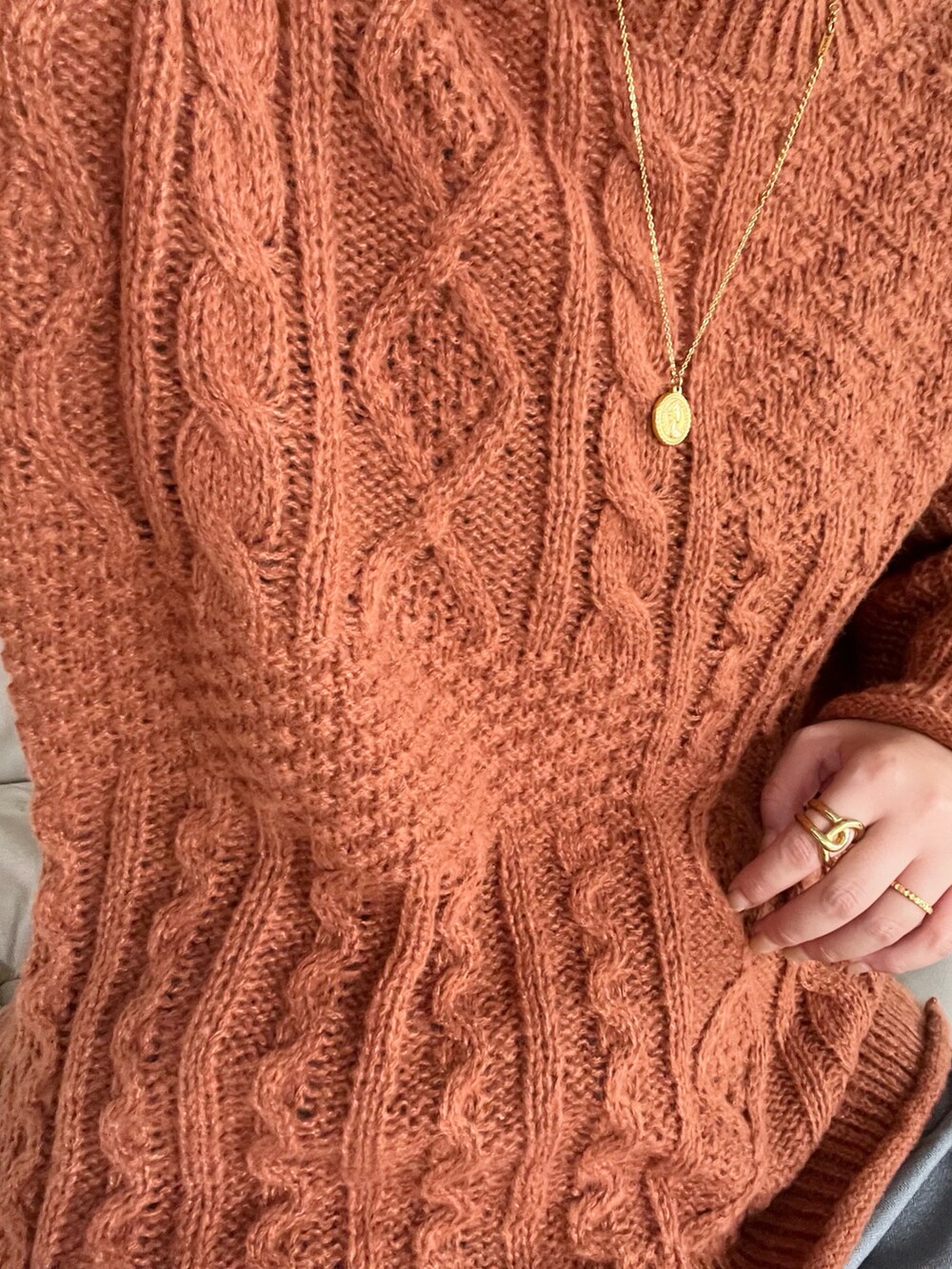 ブラック系のジャケット/アウター、オレンジ系のニット/セーター、グレー系のパンツを着用したレディースの秋コーディネートの4枚目の写真