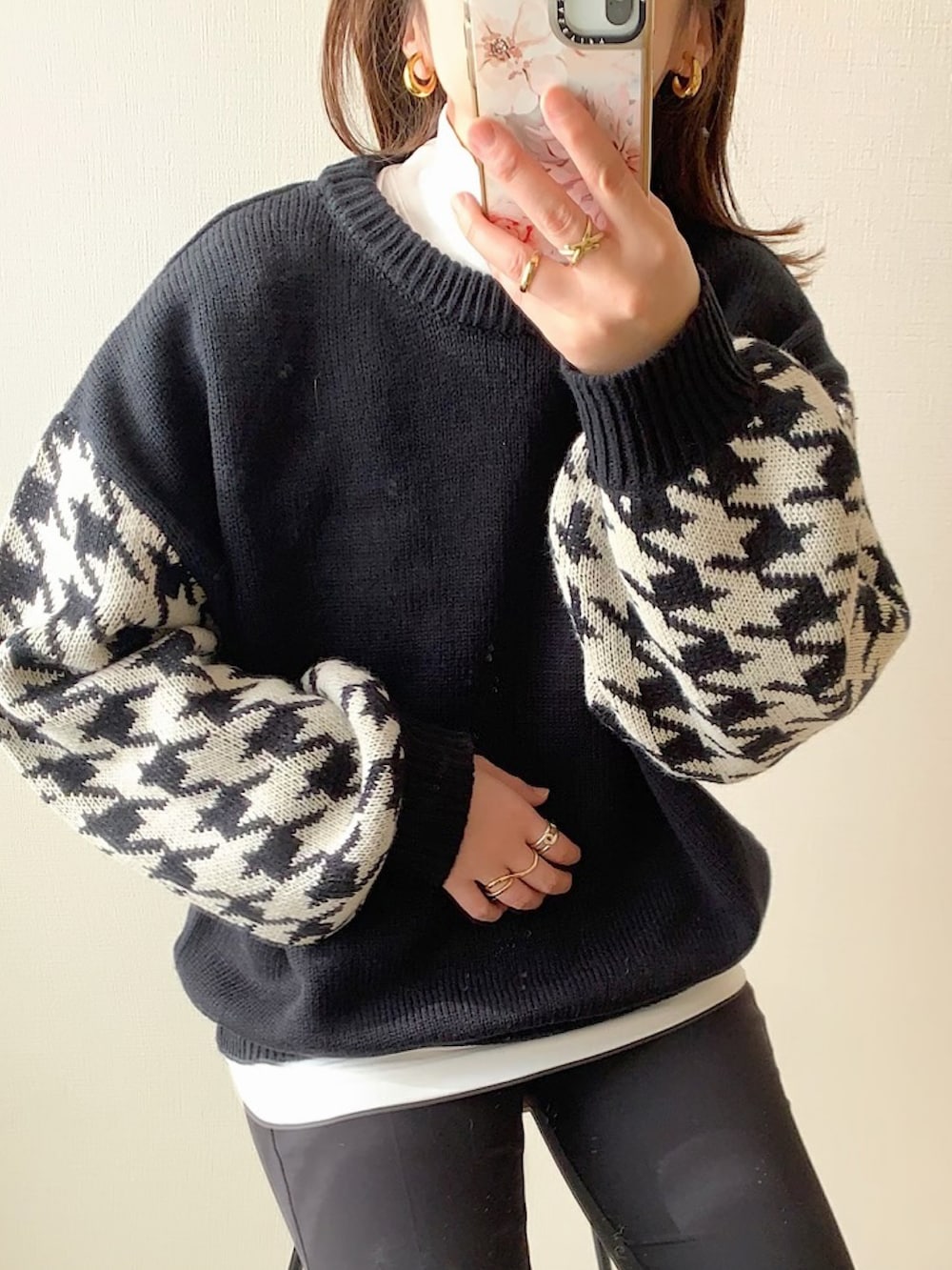 ブラック系のニット/セーター、ブラック系のデニムパンツ、ホワイト系のスニーカーを着用したレディースの冬コーディネートの3枚目の写真