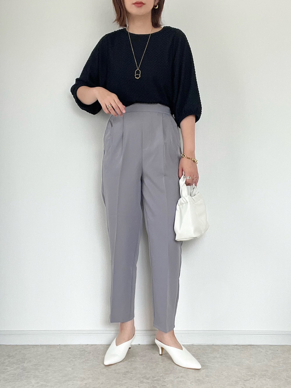 ブラック系のパンプス、ブラック系のバッグ、ブラック系のベストを着用したレディースの夏コーディネートの3枚目の写真