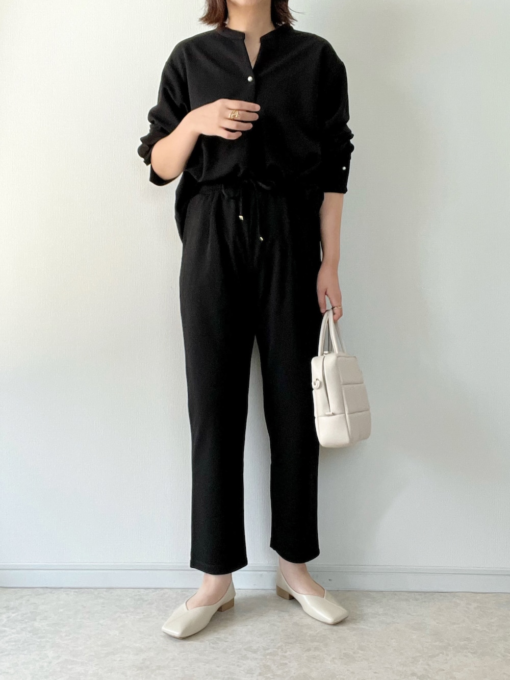 ブラック系のTシャツ/カットソー、ブラック系のその他パンツ、ホワイト系のショルダーバッグを着用したレディースの秋コーディネートの2枚目の写真