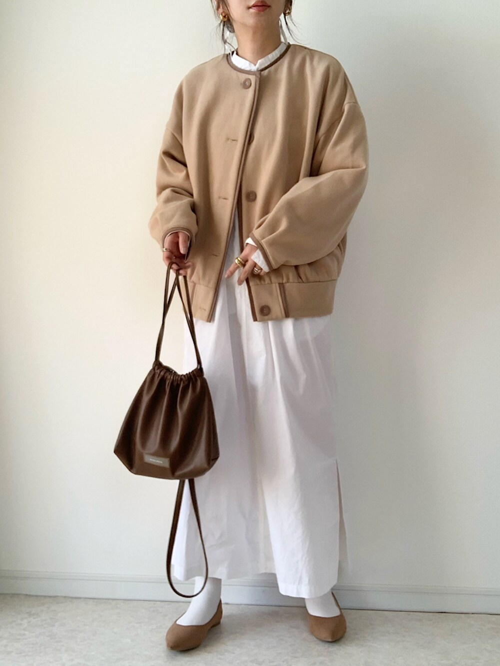 ベージュ系のカーディガン/ボレロ、ブラック系のTシャツ/カットソー、ホワイト系のデニムパンツを着用したレディースの秋コーディネートの3枚目の写真