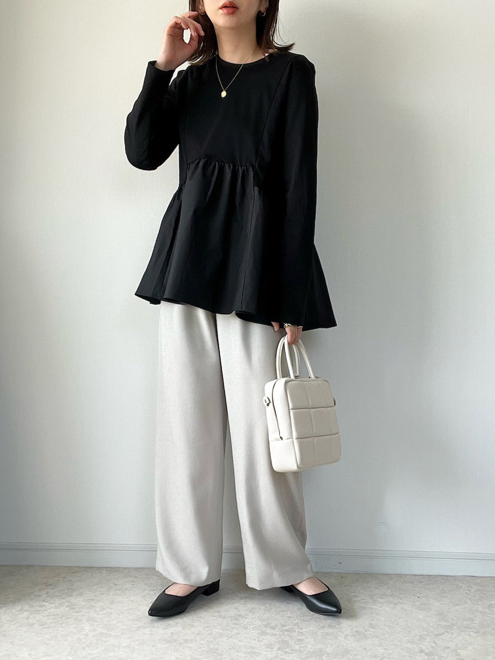 ブラック系のTシャツ/カットソー、ベージュ系のスカート、ブラック系のボストンバッグを着用したレディースの春コーディネートの2枚目の写真