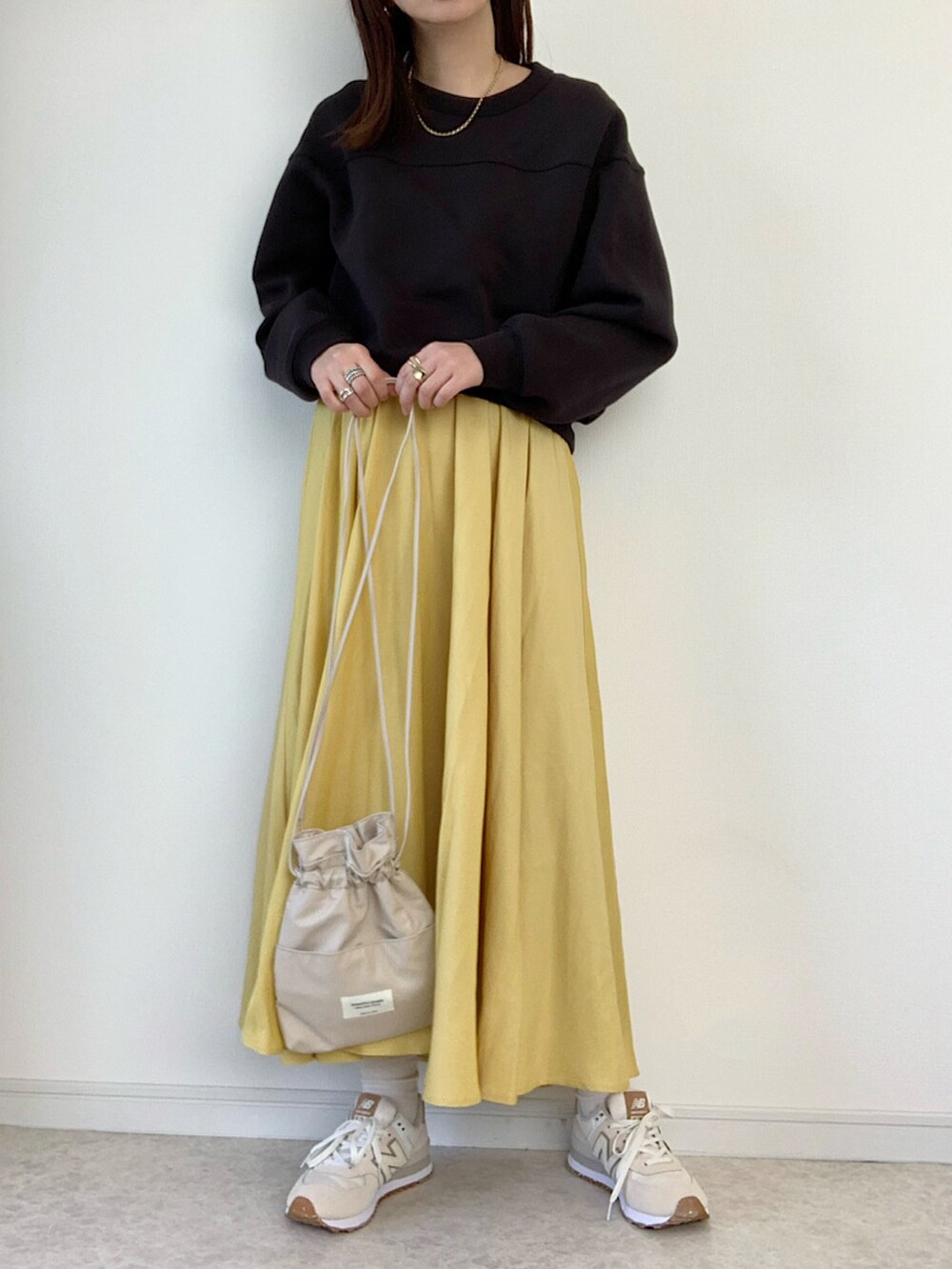 ブラック系のスウェット、ブルー系のデニムパンツ、ホワイト系のスニーカーを着用したレディースの冬コーディネートの2枚目の写真