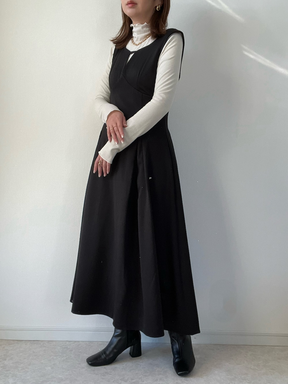 ブラック系のその他アウター、ブラック系のワンピース/ドレス、ホワイト系のハンドバッグを着用したレディースの冬コーディネートの2枚目の写真