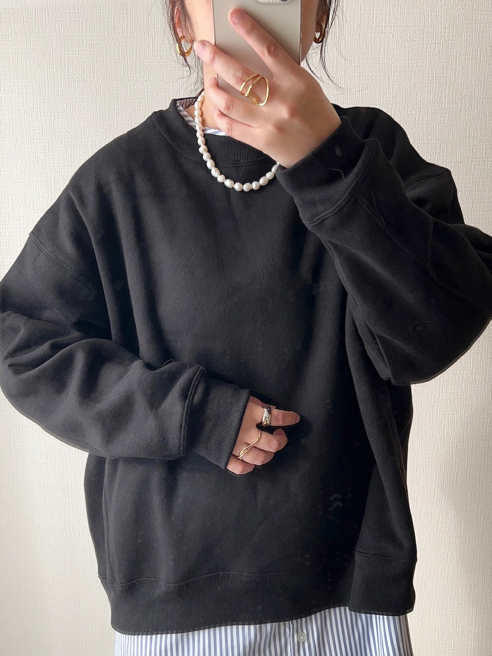 ブラック系のスウェット、グレー系のシャツワンピース、ベージュ系のショルダーバッグを着用したレディースの秋コーディネートの2枚目の写真