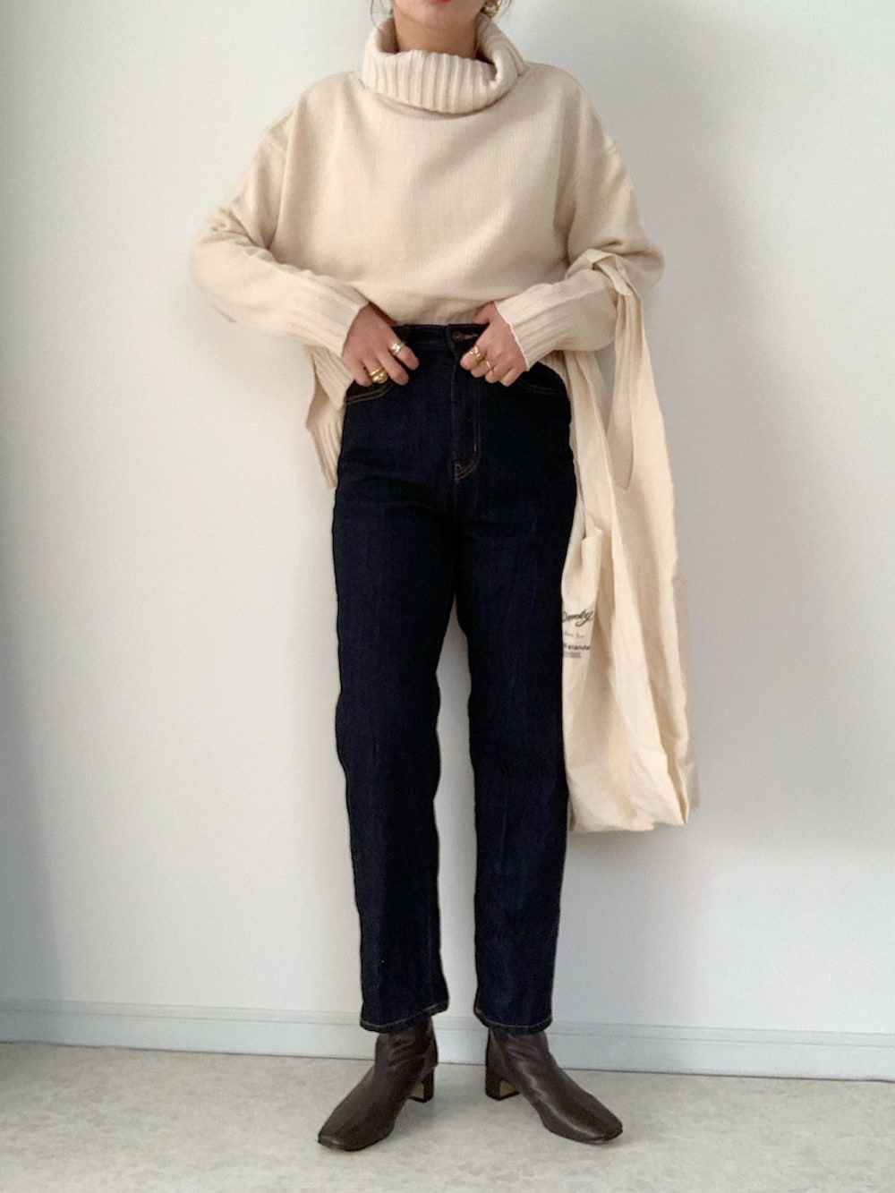 ブラウン系のチェスターコート、ホワイト系のセットアップ、ブラウン系のブーツを着用したレディースの秋コーディネートの3枚目の写真