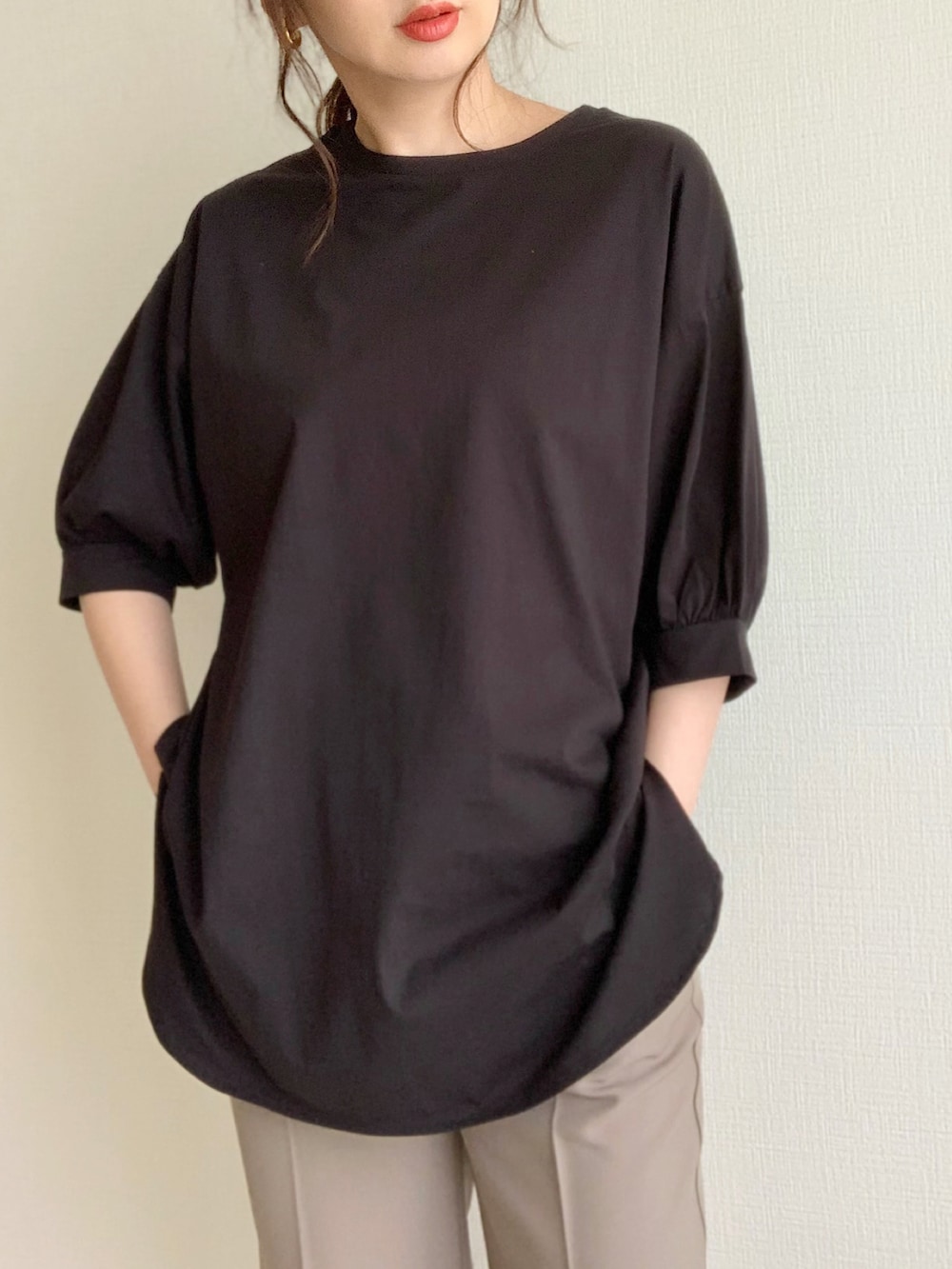 ブラック系のTシャツ/カットソー、グレー系のスラックス、ホワイト系のパンプスを着用したレディースの夏コーディネートの2枚目の写真