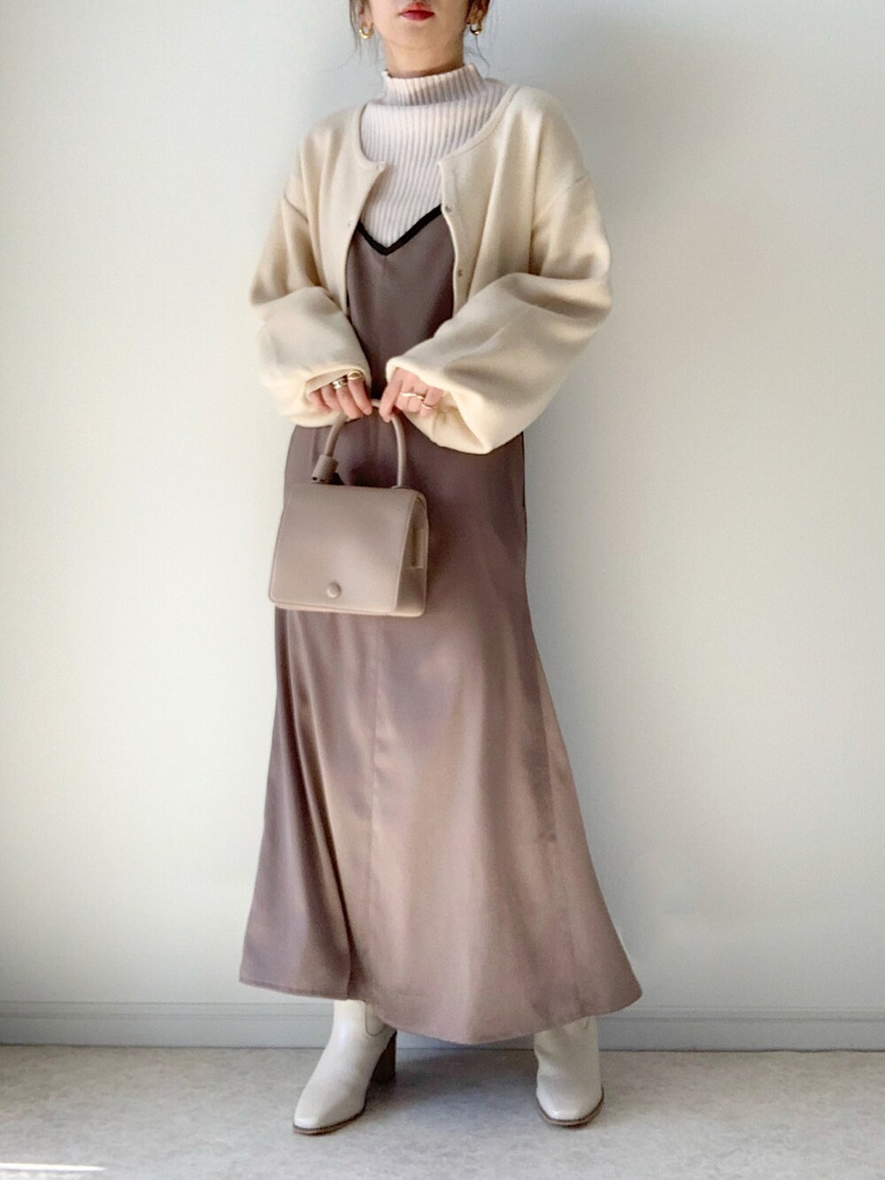 ホワイト系のニット/セーター、グレー系のワンピース、ホワイト系のブーツを着用したレディースの秋コーディネートの2枚目の写真