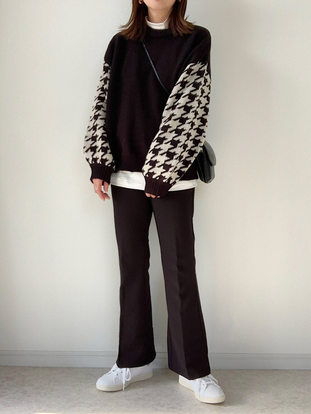 ホワイト系のニット/セーター、ホワイト系のTシャツ/カットソー、ブラック系のパンツを着用したレディースの冬コーディネートの3枚目の写真